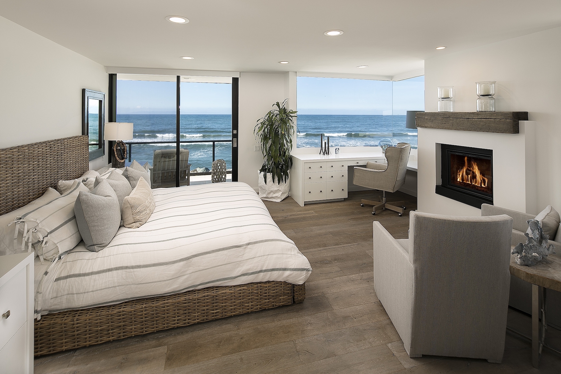 bedroom with fireplace and view of ocean
